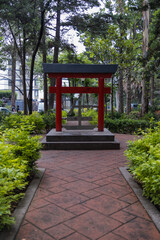Traditional Japanese gate and symbol surrounded by trees in park