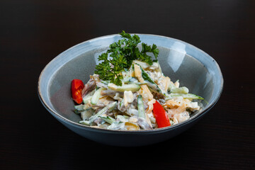 Salad with meat, vegetables and mayo on a black background