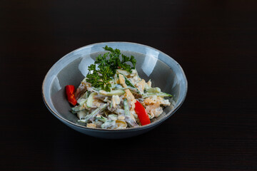 Top view of salad with meat, vegetables and mayo on a black background