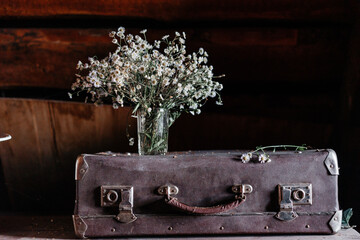Summer bouquet of white daisies, in a glass vase, on a wooden background. High quality photo