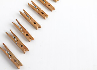 wooden clothespins lie in a row on a white background. Space for text