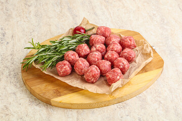 Raw uncooked beef meatballs served rosemary