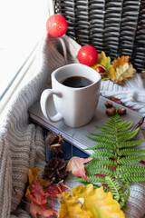 Autumn coffee in a gray cup on the window. Scattered with sheets and books lie