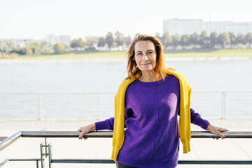 Relaxed friendly trendy middle-aged woman in colorful outfit