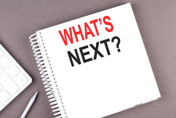 WHAT'S NEXT text on the notebook with calculator and pen