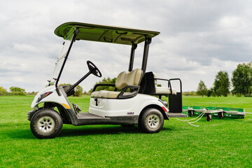 an electric car with a trailer for collecting balls on the golf course. 