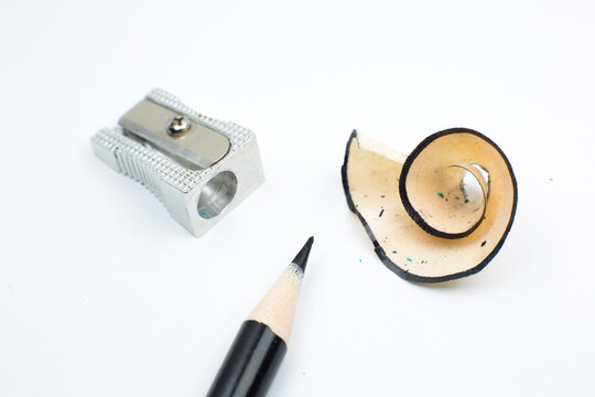 Sharpener and a broken pencil. Shavings and a graphite on white background. Close up, Macro photo. Back to school concept.