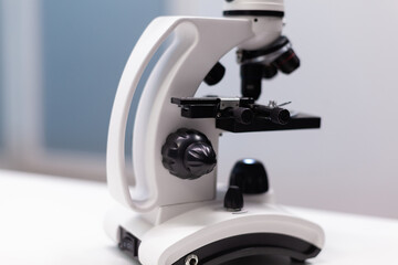 Close up of microscope with magnifying glass for biochemistry research experiment in science laboratory. Instrument with lens and glass tray for dna sample examination and healthcare