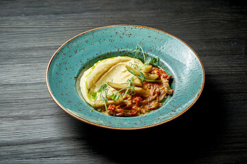Classic dish of Russian cuisine Beef Stroganoff with mashed potatoes in a blue plate on a wooden background