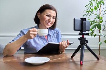 Middle aged business woman, counselor, mentor in a video meeting, using a smartphone