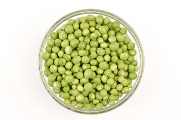 Green peas lie in a round glass plate on a white background.Cultivation and care of agriculture, harvesting, gardening, agronomy, breeding, vegetarianism, protein production, sports nutrition.