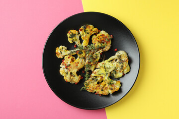 Plate with baked cauliflower on two tone background