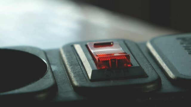 human figer press and off red lighting outlet switch on black Electric Extension Cord, closeup,