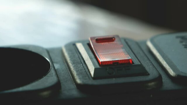 human figer press and off red lighting outlet switch on black Electric Extension Cord, closeup,