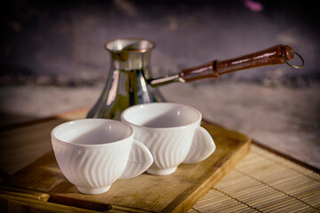 Coffee is poured into white cups. Toasted bread. Breakfast on the table.