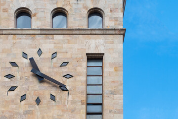 Large analog clock on a travertine tower