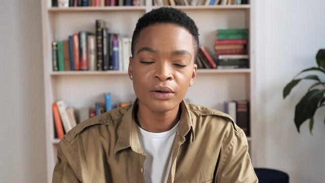 African American woman wearing a suit look to camera talking to business partner agrees nods head through online connection conference. Distance communication concept video call. Isolation pandemic. 