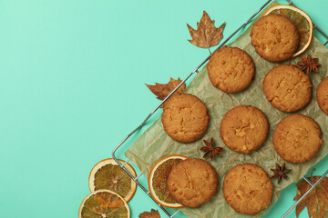 Concept of tasty food with pumpkin cookies on mint background