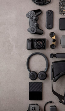 Overhead Flat Lay Of Black Technology Devices And Gadgets On A Grey Background