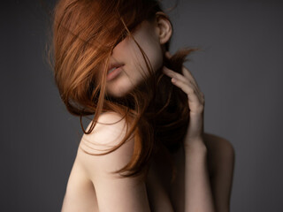woman with bare shoulders red hair posing clear skin