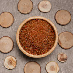 Top view of wooden bowl full of dried aromatic oriental spice mix served on table with round shaped decorative circles 