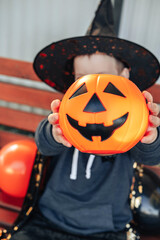 Halloween kids. Candy Basket Jack O Lantern. Cute little boy, child wearing witch hat with orange Jack O Lantern candy bucket. Happy Halloween.