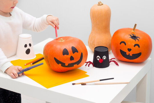 Halloween indoor activity kids craft. Pumpkin painting process. Toddler making Handmade decoration ghost and spider