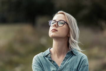 Young stylish woman in blue shirt on countryside road