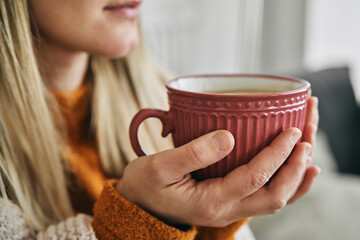 Unrecognizable woman holding a cup of hot tea