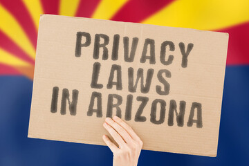 The phrase " Privacy laws in Arizona " on a banner in men's hand with blurred Finnish flag on the background. Private. Client. Market. Info. Information. Identify. Data. Security. Technology