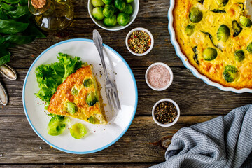 Millet quiche with brussels sprouts and ricotta on wooden table
