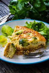 Millet quiche with brussels sprouts and ricotta on wooden table
