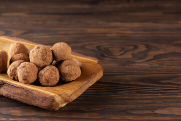 Homemade chocolate truffles on a wooden table. Sugar, gluten and lactose free, healthy diet, vegan. Horizontal orientation, copy space.