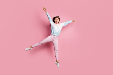 Full length body size photo of overjoyed jumping woman wearing pants knitted sweater isolated on...