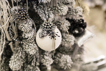 Close up of holidays location with toys and garlands on white and gray Christmas tree
