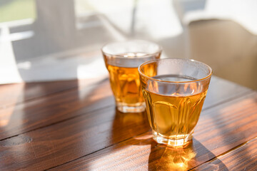 Traditional cups of tea on wooden table with light background