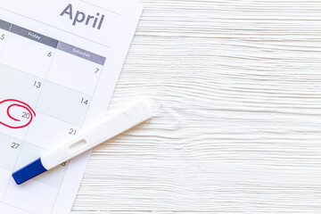 Calendar with pregnancy test, top view. Morherhood and pregnancy concept