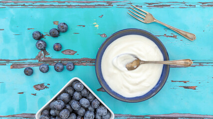 A top view, flatlay, overhead view of blueberries on a blue wooden textured background with space for text, 