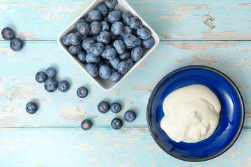 A top view, flatlay, overhead view of blueberries on a blue wooden textured background with space for text, 