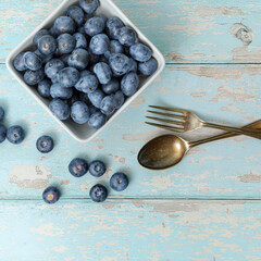 A top view, flatlay, overhead view of blueberries on a blue wooden textured background with space for text, 
