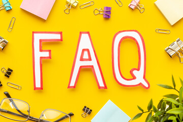 Text faq frequently asked questions on office table with stationery