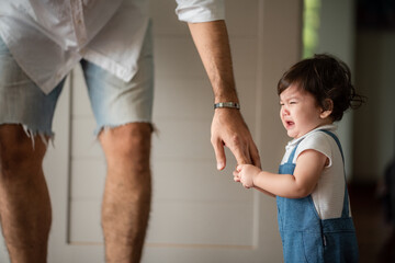 Fototapeta premium father help children baby to walk, childhood family people with little cute toddler child son, happy learning in first step with support together from father at home