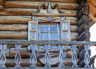 Balcony, platbands and shutters decorated with traditional Russian northern carvings. House of the Oshevnev peasants from Zaonezh. Kizhi Island. Republic of Karelia. Russia