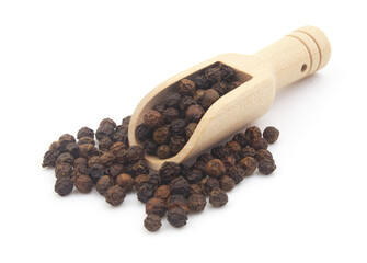 Wooden scoop on black peppercorns isolated on white background
