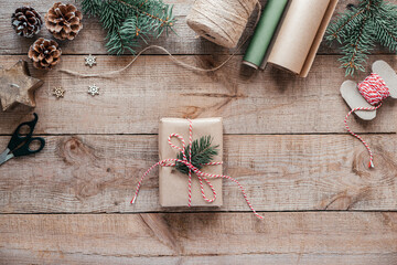 Trendy Christmas gift box wrapped in kfaft paper with pine tree branch
