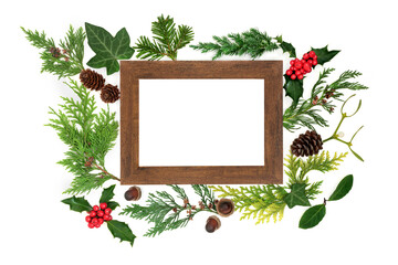 Natural European winter flora and greenery nature composition with wooden frame. Abstract winter solstice Christmas and New Year arrangement. Top view, flat lay.