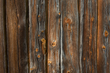Wooden logs of an old house. Close-up. Weathered natural gray wood texture. Background. Horizontal photo.
