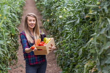 Portrait of a young woman carrying a basket of freshly picked produce in a garden. Cropped shot of an attractive young woman working on her self owned farm.