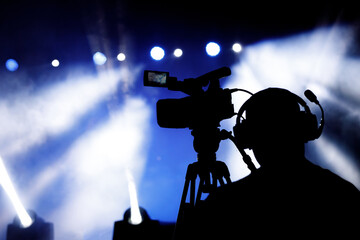 Fototapeta premium Silhouette of cameraman and camera on a concert.