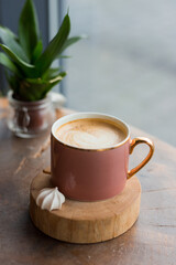One Cup of cappuccino with latte art. Coffee in pink cup on old wooden table in cafe. Concept of easy breakfast.
